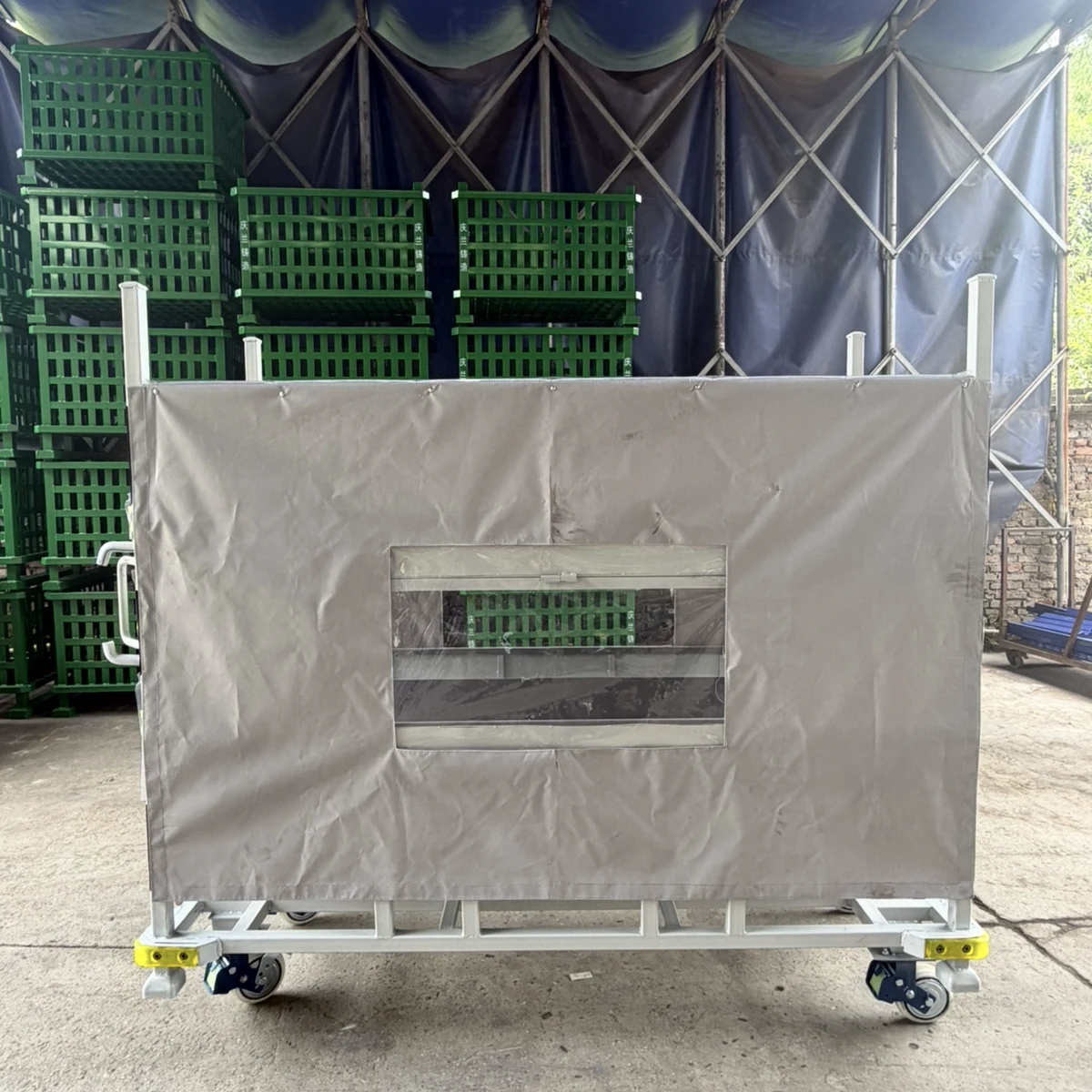 Real product photo of a covered returnable parts trolley with enclosure cover, access panel and wheeled returnable frame