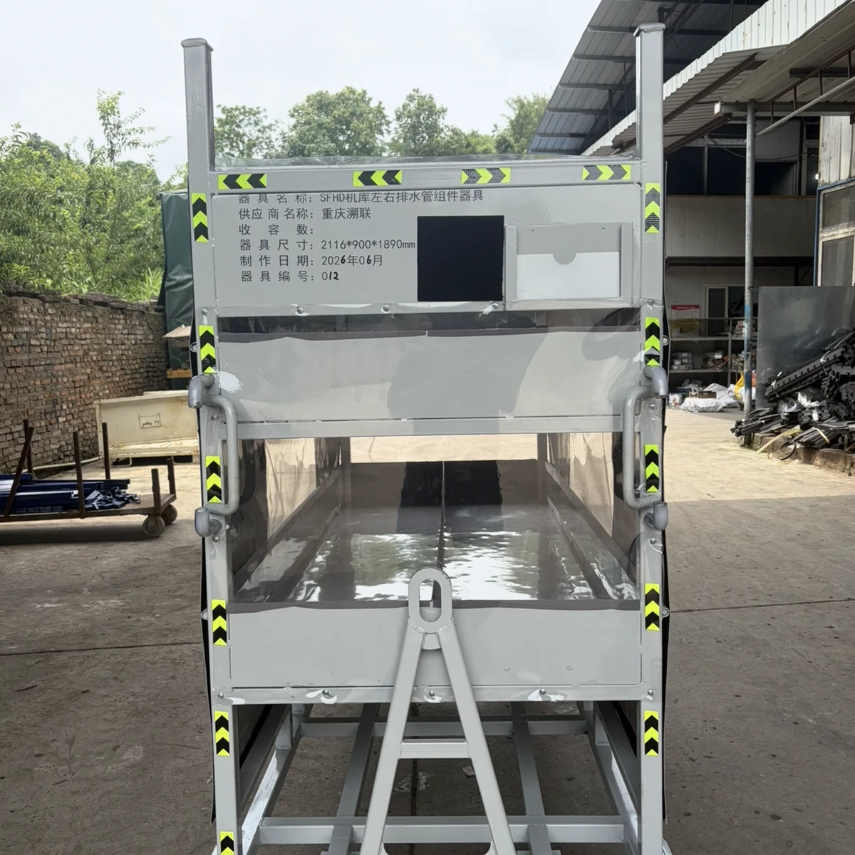 Real product photo of a covered returnable parts trolley with enclosure cover, access panel and wheeled returnable frame — configuration view 2
