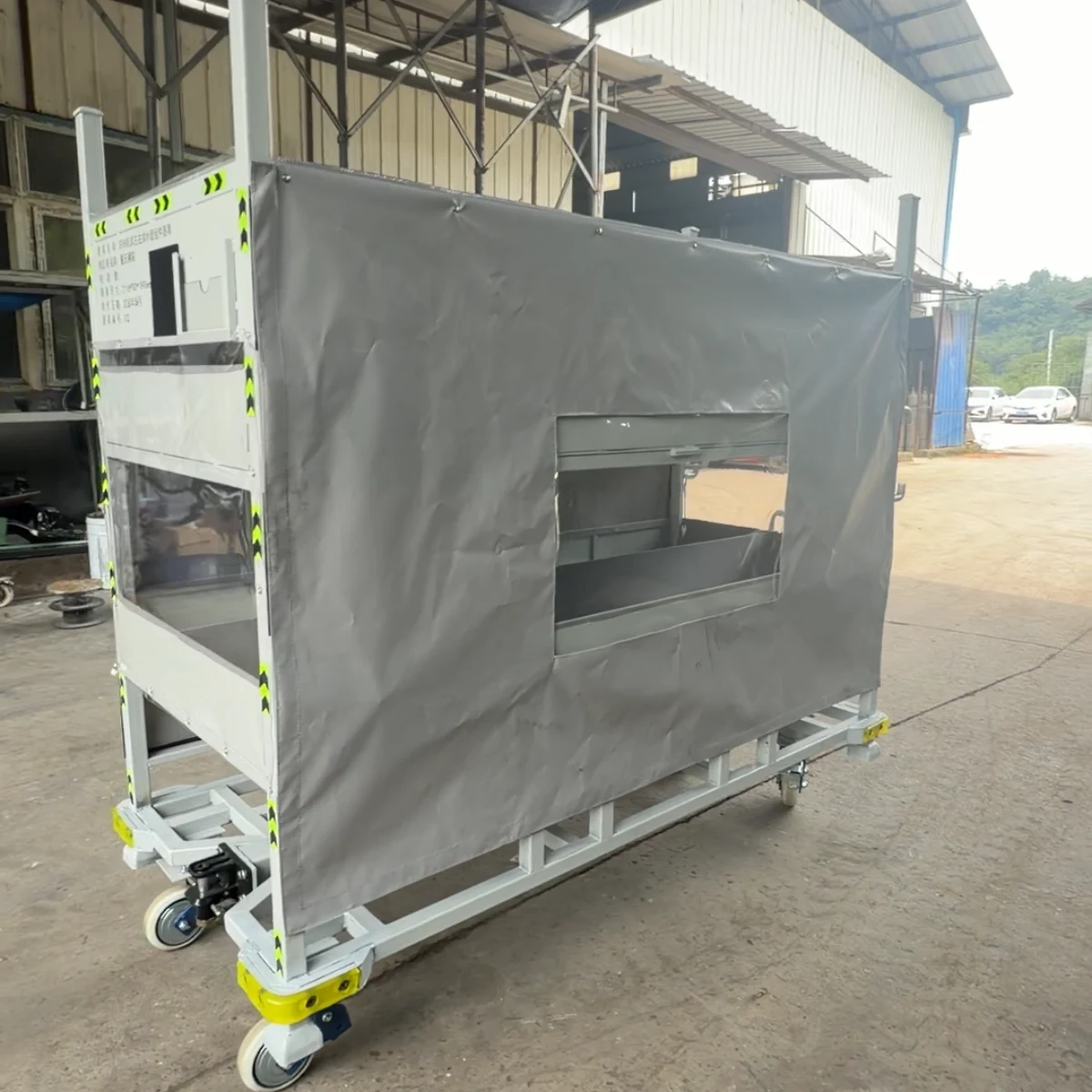 Real product photo of a covered returnable parts trolley with enclosure cover, access panel and wheeled returnable frame — configuration view 3