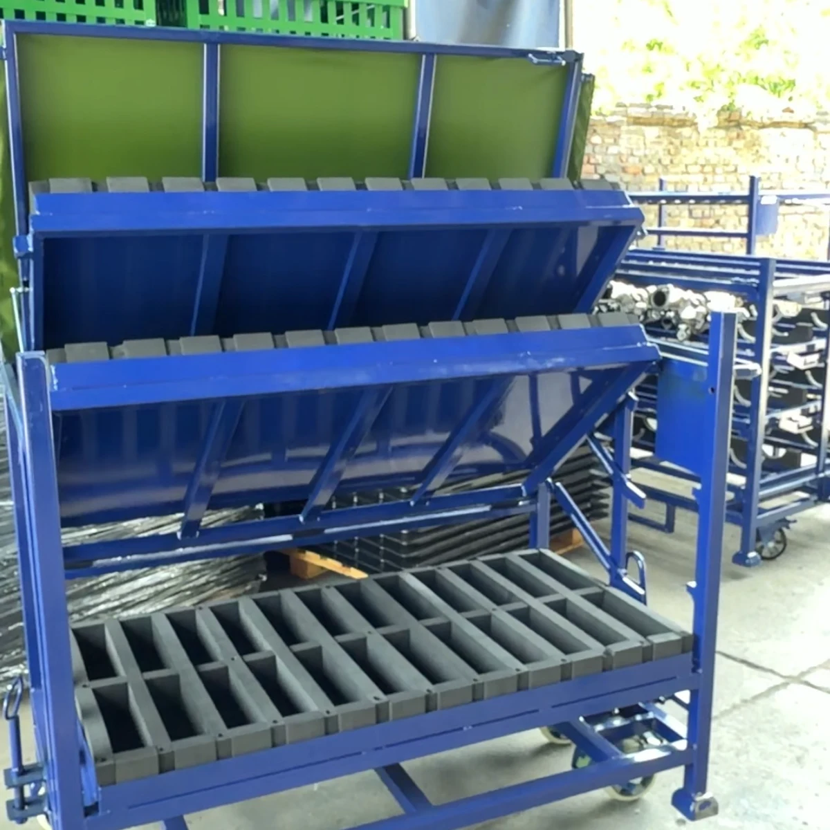 Real product photo of a gas strut tilting tray rack with gas-strut-assisted tilting trays and foam locators — configuration view 2