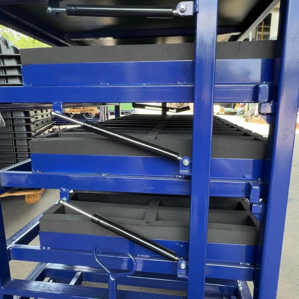 Real product photo of a gas strut tilting tray rack with gas-strut-assisted tilting trays and foam locators — configuration view 4